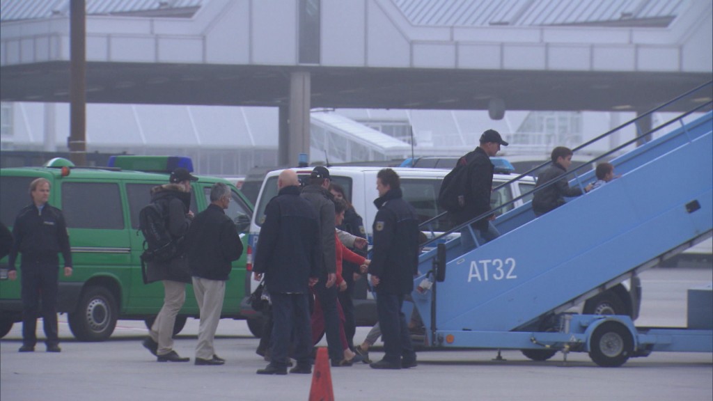 Polizeibeamte begleiten einen Afghanen für eine Abschiebung in ein Flugzeug