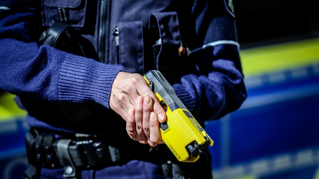 Eine Polizistin hält einen Taser in den Händen